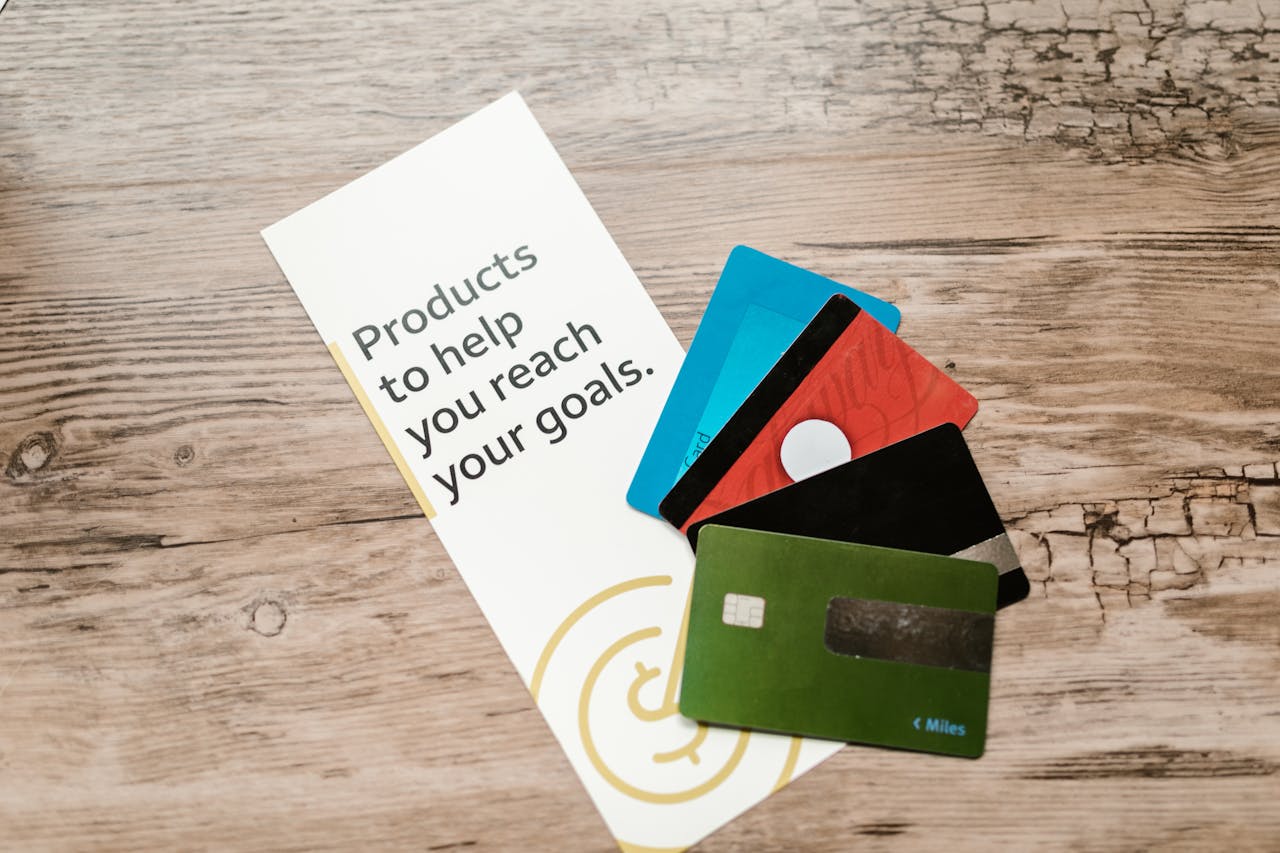 Crafting Captivating Headlines: Your awesome post title goes here Assorted credit cards on a wooden table next to a leaflet with motivational text about financial goals.